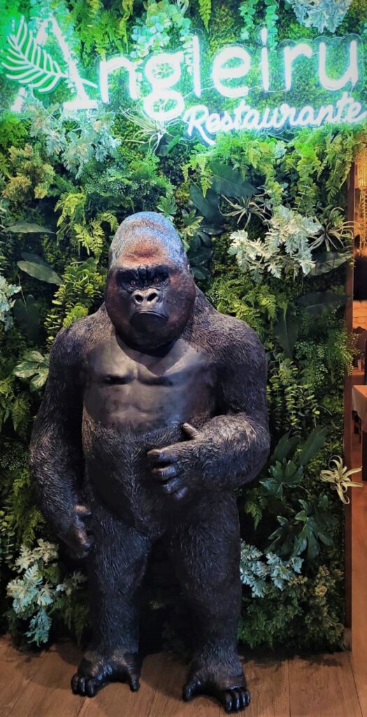 Figura de gorila con mirada penetrante erguido sobre sus pata traseras.