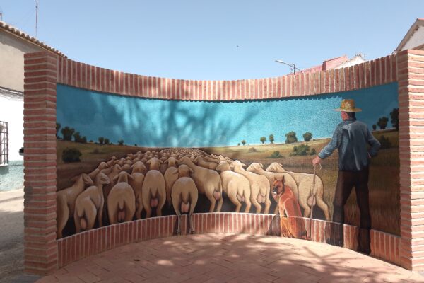 Mural exterior representando la trashumancia sobre pared vertical cóncava