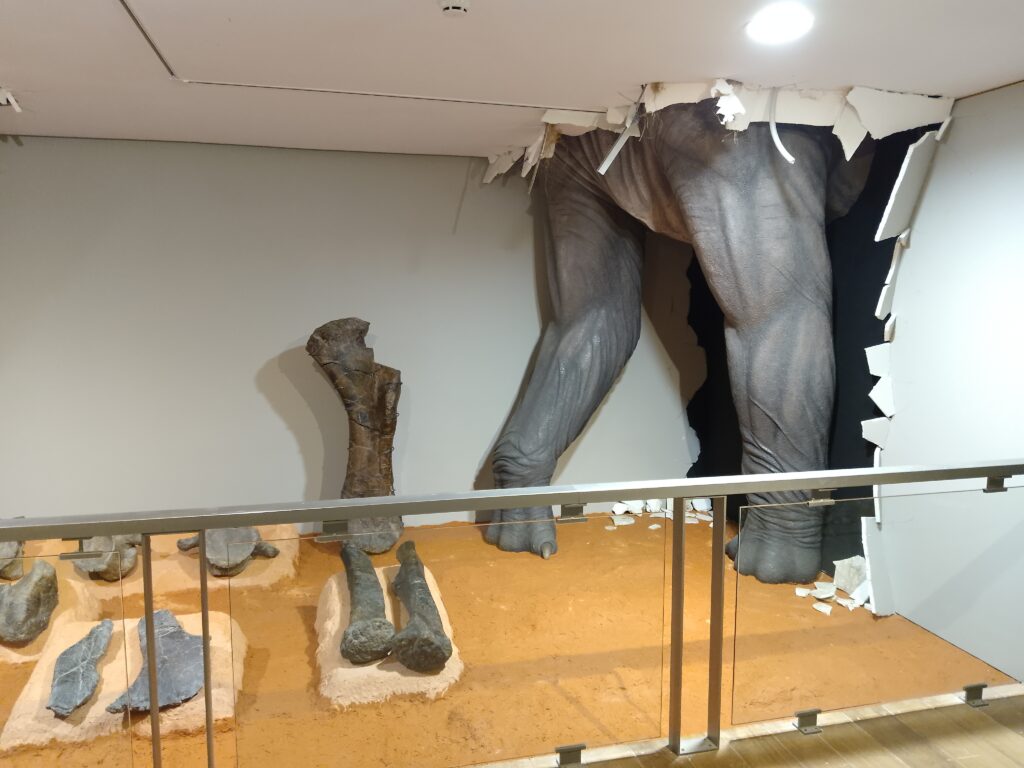 Las patas delanteras a tamaño natural rompiendo la pared